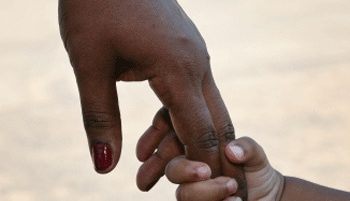 African mother holding son's little hand