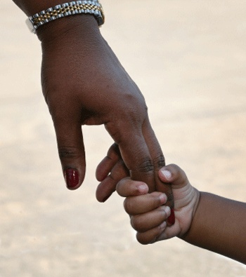 African mother holding son's little hand